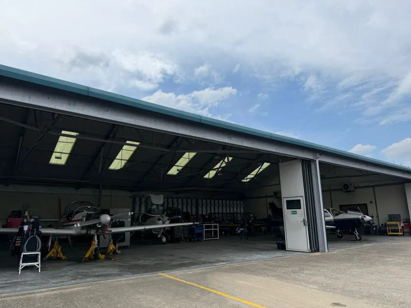 Modern hangar with its doors open and aircraft inside